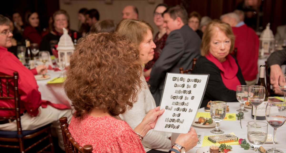 Guests at a Sherlock Holmes murder mystery analyze suspect profiles, reflecting the consistent quality of an engaging, well-crafted event