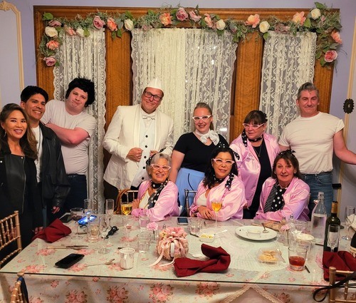 Actors in 1950s diner attire performing a thrilling murder mystery show